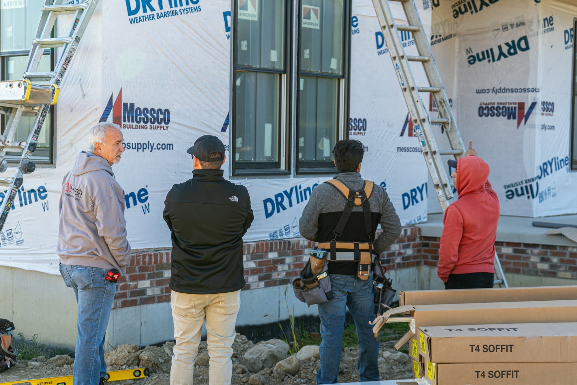 The Impact Roofing & Siding crew reviewing a job with house wrap installed