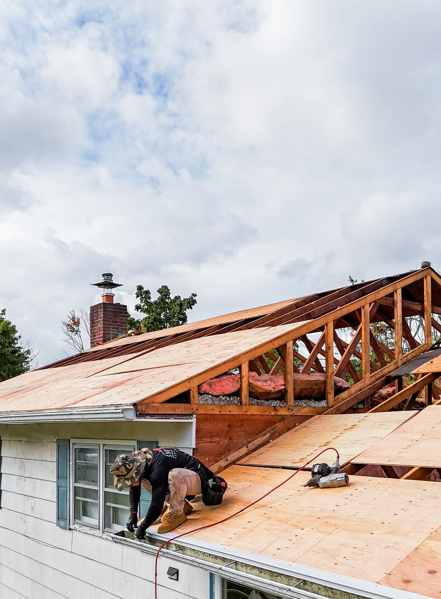 Roofer installing new plywood roof decking